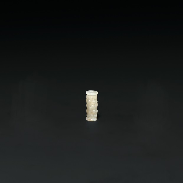 AN ARCHAIC JADE ‘GRAIN PATTERN’ BEAD